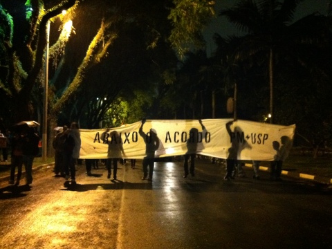 Manifestantes do dia 31 de outubro criticam o acordo que aumenta a presença da PM no Campus com cartaz cuja tipografia é característica do grupo MNN (foto: Victor Francisco Ferreira)