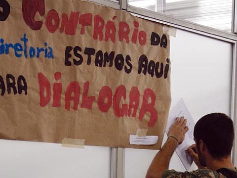 Aluno assina abaixo-assinado pela revogação dos processos durante protesto na porta da sala da Congregação (foto: Francine Segawa)