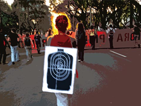 No ato do dia 9 de junho, pouco antes do confronto com a PM, aluna carrega alvo como protesto à presença policial no campus (foto: Guilherme Minotti/arte: Vandson Lima)