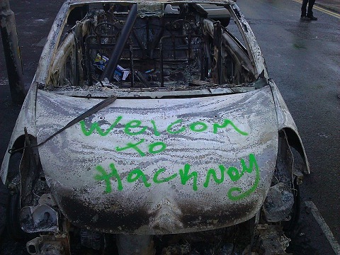 Carro incendiado e graffitado “Welcom to Hackney”, bairro londrino (foto: Alastair)